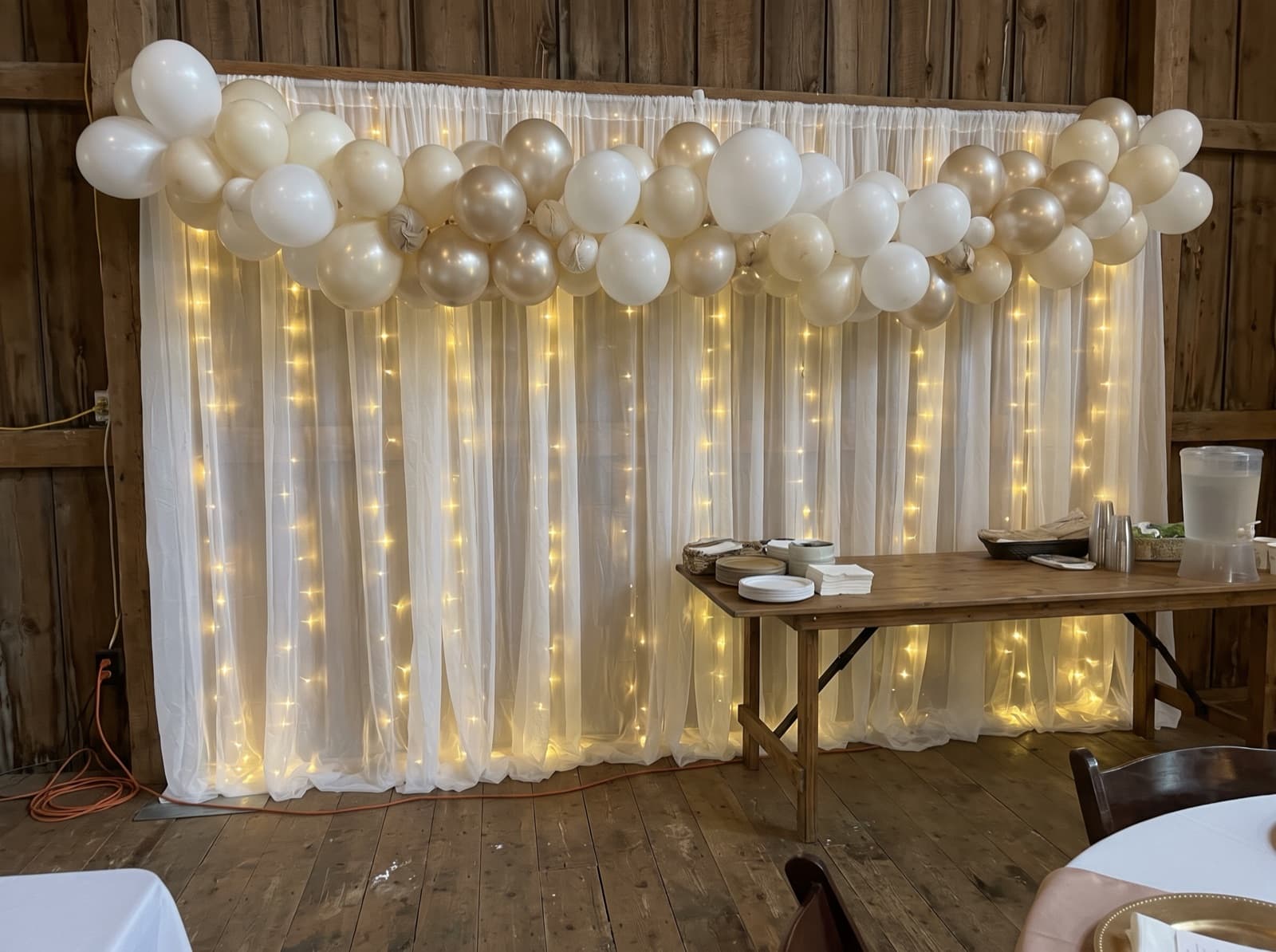 Draped backdrop with balloons and warm lights