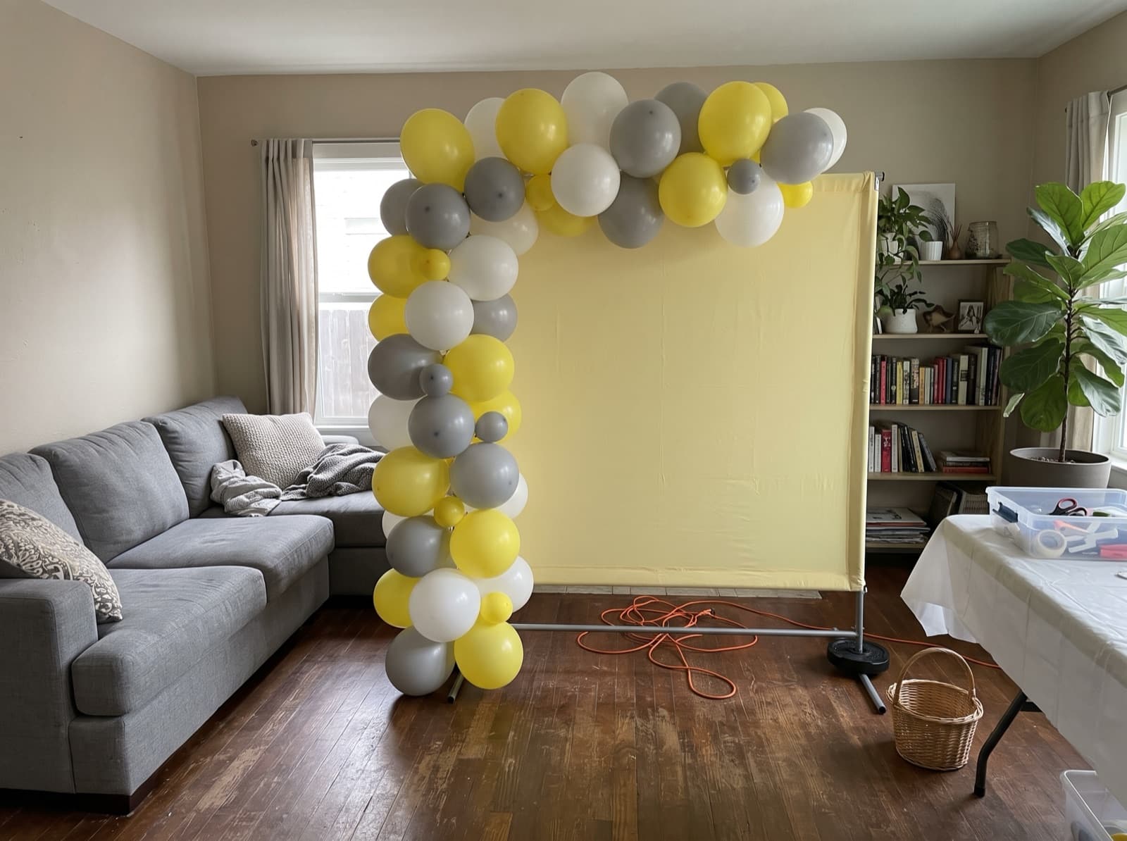 Square backdrop with a yellow and gray garland up one side