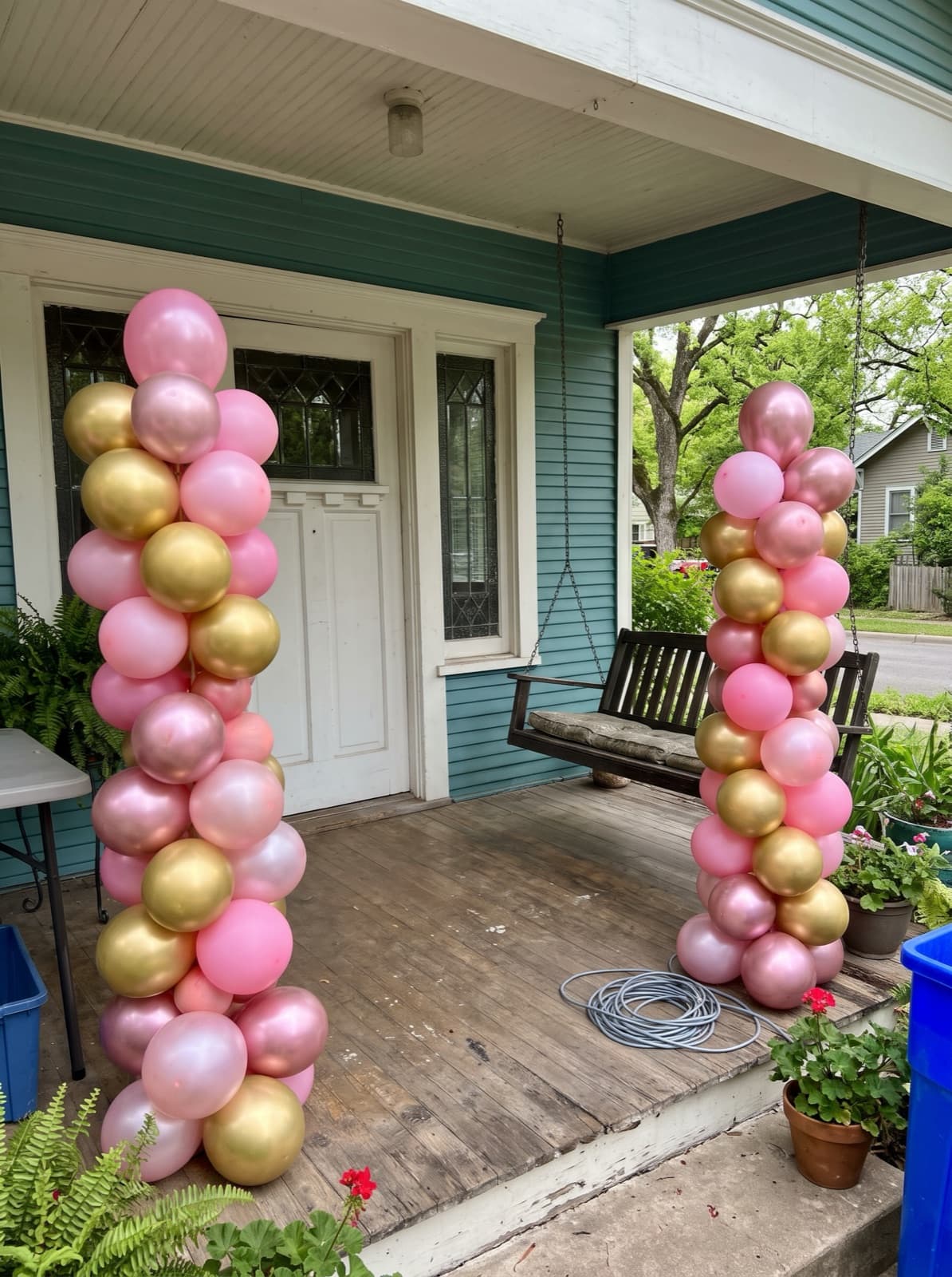 Pair of pink and gold spiral balloon columns at a front door