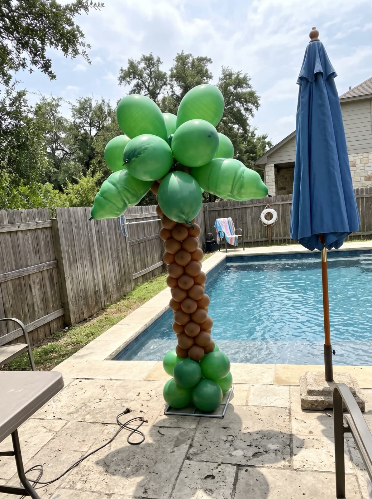 Palm tree balloon column beside a pool