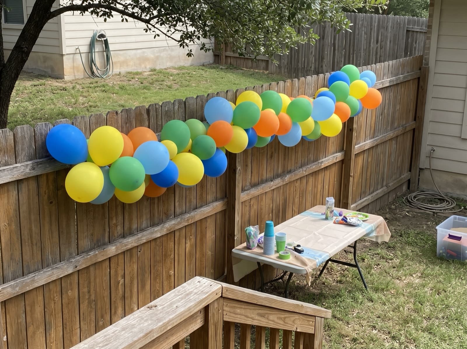 Grab-and-go balloon garland on a backyard cedar fence
