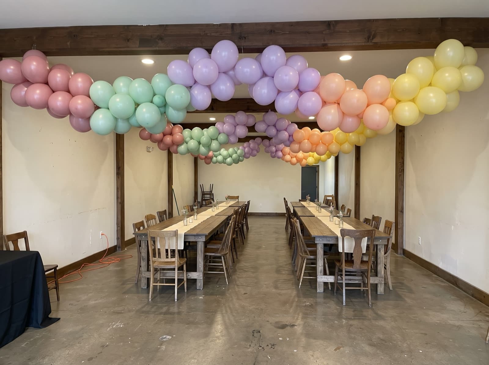 Hanging balloon garland canopy over long tables