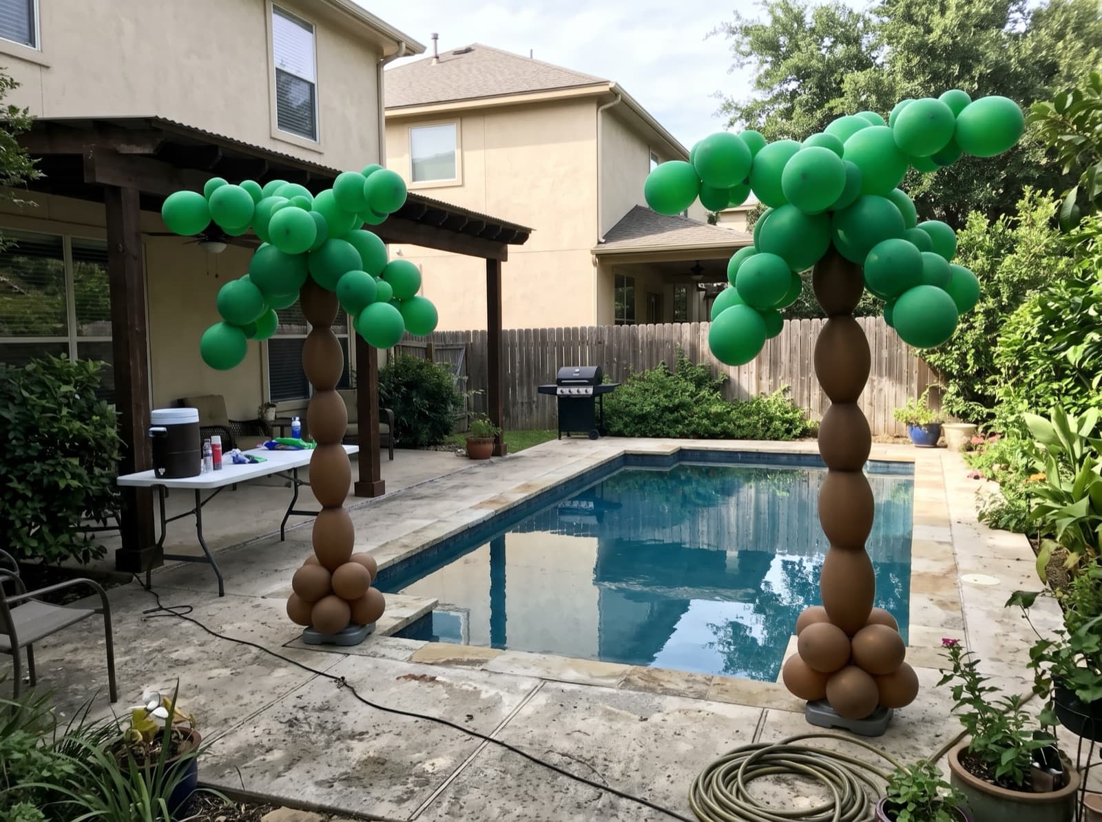 Balloon palm trees beside a backyard pool